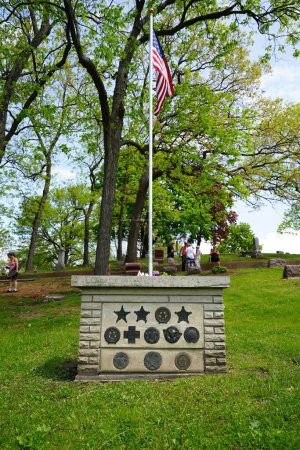 Téléchargez les photos : Oconomowoc, Wisconsin / États-Unis - 25 mai 2020 : Des rubans commémoratifs d'officiers militaires tombés au champ d'honneur sur une tombe de soldat inconnue au cimetière de la belle en souvenir de leur service le jour du Souvenir. - en image libre de droit