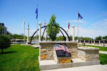 Foto de Oconomowoc, Wisconsin / Estados Unidos - 25 de mayo de 2020: Oconomowoc veteran memorial site sits between lake fowler and lac la belle giving honor and remembrance to all the brave men and women that have fought. - Imagen libre de derechos