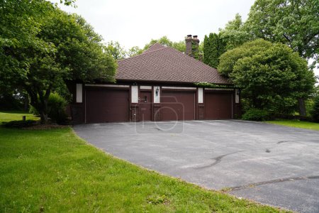 Photo for Fond du Lac, Wisconsin / USA - June 6th, 2019: Outside side view of a 3 vehicle garage of a 1970s house outside of Fond du Lac, Wisconsin - Royalty Free Image