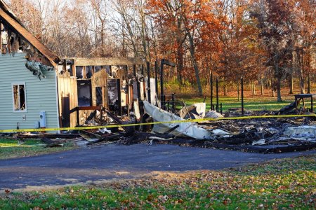 Téléchargez les photos : Une maison incendiée par un incendie dans la campagne près d'une forêt. - en image libre de droit