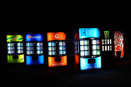 Foto de Nueva Lisboa, Wisconsin, EE.UU. - 17 de noviembre de 2023: Las máquinas expendedoras de refrescos y bebidas se sientan a la orilla de la carretera brillando durante la noche. - Imagen libre de derechos