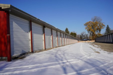 Foto de Unidades de almacenamiento extra grandes rojas y blancas usadas para la comunidad se sientan afuera durante el frío del invierno.. - Imagen libre de derechos