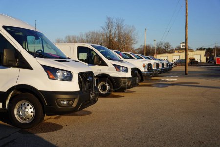 Foto de Ripon, Wisconsin, EE.UU. - 10 de diciembre de 2023: furgonetas de carga Ford blancas alineadas en una fila que se venden en un concesionario. - Imagen libre de derechos