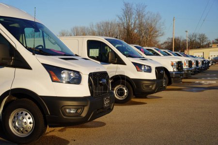 Foto de Ripon, Wisconsin, EE.UU. - 10 de diciembre de 2023: furgonetas de carga Ford blancas alineadas en una fila que se venden en un concesionario. - Imagen libre de derechos