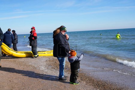 Foto de Milwaukee, Wisconsin / Estados Unidos - 1 de enero de 2020: Muchos miembros de la comunidad participaron en Polar Bear Sumérgete en las heladas aguas del lago Michigan durante la fría temporada de invierno. - Imagen libre de derechos