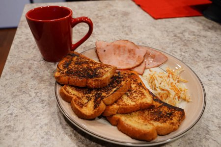 Téléchargez les photos : Matin Petit déjeuner composé de pain perdu, de jambon tranché et de pommes de terre hachées avec une tasse de café. - en image libre de droit