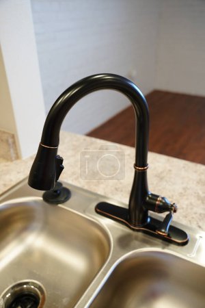 Photo for Black vintage looking sprayer faucet used on a kitchen sink. - Royalty Free Image