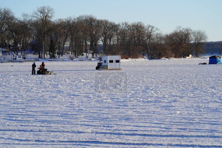 Téléchargez les photos : Green Lake, Wisconsin États-Unis - 20 janvier 2024 : Des gens pêchent sur la glace sur un lac gelé dans des cabanes à glace. - en image libre de droit