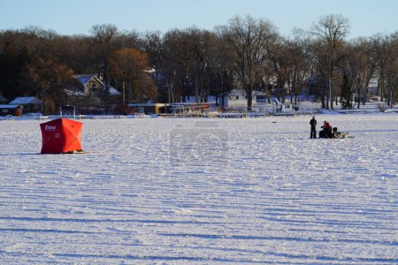 Foto de Green Lake, Wisconsin, EE.UU. - 20 de enero de 2024: La gente pesca en hielo en un lago congelado en chabolas de hielo. - Imagen libre de derechos