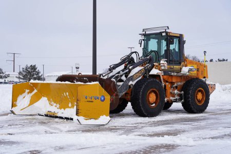 Téléchargez les photos : Mauston, Wisconsin États-Unis - 15 janvier 2024 : La chargeuse sur pneus pleine grandeur Case se trouve dans la neige d'hiver prête à être utilisée. - en image libre de droit
