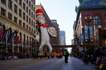 Foto de Chicago, Illinois, Estados Unidos - 23 de noviembre de 2023: Miembros del Desfile del Día de Acción de Gracias de Chicago tiraron del globo del personaje del Dr. Seuss en el sombrero por State Street. - Imagen libre de derechos