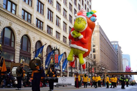 Téléchargez les photos : Chicago, Illinois États-Unis - 23 novembre 2023 : Des membres du Chicago Thanksgiving Day Parade ont tiré le ballon de personnage Grinch à travers State Street. - en image libre de droit