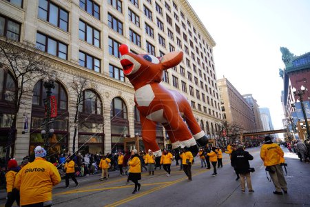 Foto de Chicago, Illinois, Estados Unidos - 23 de noviembre de 2023: Miembros del Desfile del Día de Acción de Gracias de Chicago tiraron de Rudolph el globo de carácter de reno nariz roja a través de State Street. - Imagen libre de derechos
