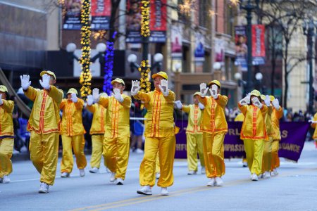 Téléchargez les photos : Chicago, Illinois États-Unis - 23 novembre 2023 : Des membres du Falun Dafa Chicago, Falun Gong Chicago une pratique religieuse chinoise participent au défilé de l'Action de grâces de Chicago en 2023. - en image libre de droit