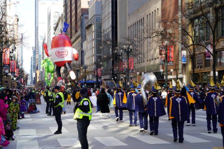 Foto de Chicago, Illinois, Estados Unidos - 23 de noviembre de 2023: Miembros del Desfile del Día de Acción de Gracias de Chicago tiraron del globo del personaje de Grinch a través de State Street. - Imagen libre de derechos