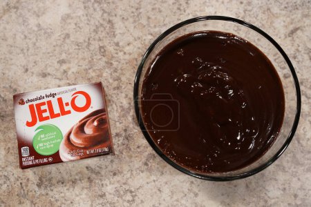 Photo for Fond du Lac, Wisconsin USA - February 15th, 2024: A box of Jell-O 3.9 oz Chocolate Fudge instant Pudding mix next to a bowl of Chocolate pudding. - Royalty Free Image