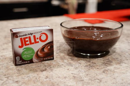 Téléchargez les photos : Fond du Lac, Wisconsin États-Unis - 15 février 2024 : Une boîte de mélange instantané au chocolat au caramel à la confiture de 3,9 oz à côté d'un bol de pudding au chocolat. - en image libre de droit