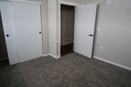 Foto de Dormitorio alfombrado gris dentro de una unidad de apartamento. - Imagen libre de derechos