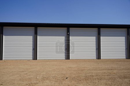 Foto de Unidades de almacenamiento de puertas grises y blancas en la carretera son utilizadas por la comunidad. - Imagen libre de derechos