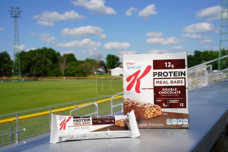 Foto de Beaver dam, Wisconsin / Estados Unidos - 27 de junio de 2020: Especial K Protein Meal Bar, Double Chocolate 6 pack, 1.59 oz bars 5 gramos de fibra y 12 minerales y vitaminas se sienta en el banco en el campo de fútbol. - Imagen libre de derechos