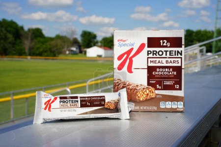 Photo for Beaver dam, Wisconsin / USA - June 27th, 2020: Special K Protein Meal Bar, Double Chocolate 6 pack, 1.59 oz bars 5 grams of fiber and 12 minerals and vitamins sits on bench at football field. - Royalty Free Image