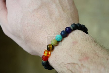 Téléchargez les photos : Bracelet en perles de chakra de roche de lave au poignet d'un homme - en image libre de droit