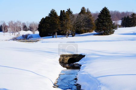 Téléchargez les photos : Petit ruisseau d'eau coule à travers un paysage de saison d'hiver en dehors de Campbellsport, Wisconsin et Lomira, Wisconsin campagne. - en image libre de droit