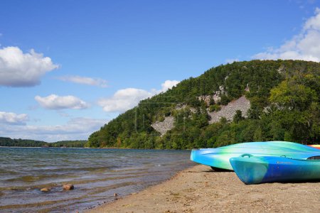 Photo for Baraboo, Wisconsin USA - September 21st, 2021: Colorful kayaks sit on sandy beach at Devil's Lake state park. - Royalty Free Image