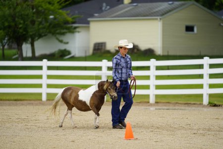 Foto de Fond du Lac, Wisconsin / Estados Unidos - 17 de julio de 2019: Muchacho joven con caballo en exhibición de caballos en un campo público de caballos en Fond du Lac, Wisconsin - Imagen libre de derechos