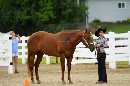 Foto de Fond du Lac, Wisconsin / Estados Unidos - 17 de julio de 2019: Muchacha joven con caballo en exhibición de caballos en un campo público de caballos en Fond du Lac, Wisconsin - Imagen libre de derechos