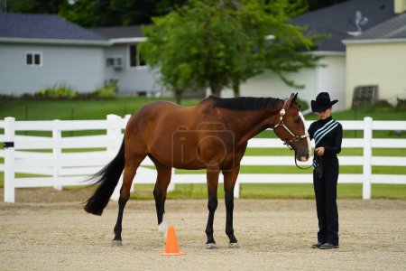 Photo for Fond du Lac, Wisconsin / USA - July 17th, 2019: Young girl with horse at horse show at a public horse ranch field in Fond du Lac, Wisconsin - Royalty Free Image