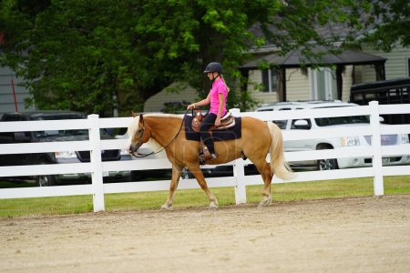 Foto de Fond du Lac, Wisconsin / Estados Unidos - 17 de julio de 2019: Niña montando a caballo en un campo público de caballos en Fond du Lac, Wisconsin - Imagen libre de derechos