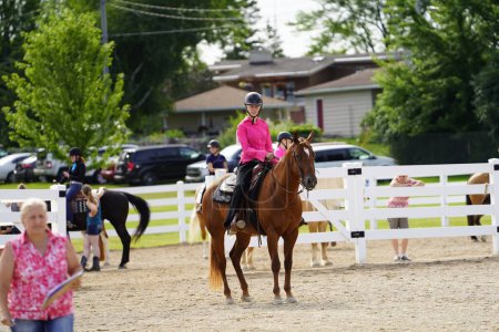 Téléchargez les photos : Fond du Lac, Wisconsin / États-Unis - 17 juillet 2019 : Jeune fille chevauchant son cheval sur un champ de ranch public à Fond du Lac, Wisconsin - en image libre de droit