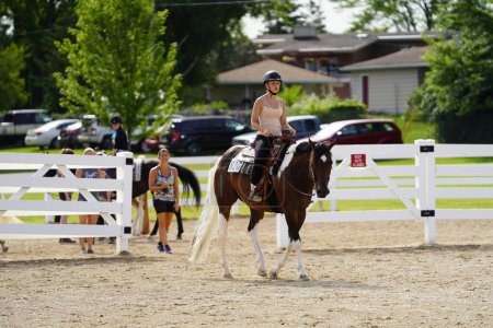 Téléchargez les photos : Fond du Lac, Wisconsin / États-Unis - 17 juillet 2019 : Jeune fille chevauchant son cheval sur un champ de ranch public à Fond du Lac, Wisconsin - en image libre de droit