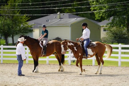 Foto de Fond du Lac, Wisconsin / Estados Unidos - 17 de julio de 2019: Chicas montando a caballo en un campo público de caballos en Fond du Lac, Wisconsin - Imagen libre de derechos
