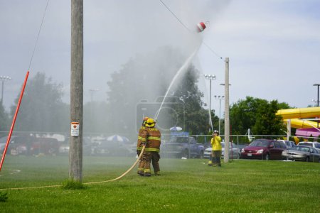 Téléchargez les photos : Fond du Lac, Wisconsin États-Unis - 20 juillet 2019 : Des pompiers locaux de la communauté ont tenu un match de boule d'eau pour pompiers lors de la foire du comté de Fond du Lac. - en image libre de droit
