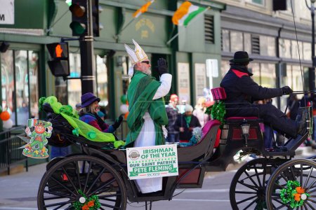 Foto de Milwaukee, Wisconsin, EE.UU. - 12 de marzo de 2022: Un hombre vestido como San Patricio saludó a los espectadores desde su carrito en el desfile del Día de San Patricio. - Imagen libre de derechos