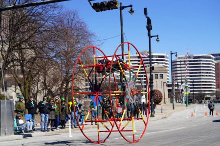 Téléchargez les photos : Milwaukee, Wisconsin États-Unis - 12 mars 2022 : Un Afro-américain fait de la gymnastique avec sa roue allemande au défilé de la Saint-Patrick. - en image libre de droit