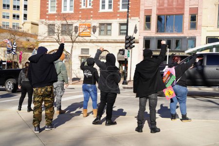 Photo for Madison, Wisconsin / USA - November 1st, 2020: Anti-trump members of black lives matter stand in protest against the blue lives matter and trump convoy rally driving around in the streets. - Royalty Free Image