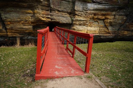 Eine rote künstliche Brücke führt in einen Felstunnel am Pier County Park in Rockbridge, Wisconsin, einer historischen Stätte der Ureinwohner Amerikas.