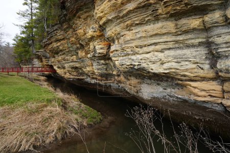 Un puente rojo hecho por el hombre conduce a un túnel de roca en Pier County Park en Rockbridge, Wisconsin un sitio histórico nativo americano.