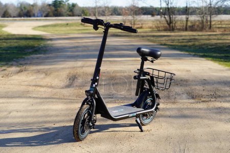Photo for New Lisbon, Wisconsin USA - April 13th, 2024: A Gyroor electric scooter sit down bike sits standing up on a dirt road outside. - Royalty Free Image