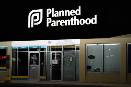 Photo for Oshkosh, Wisconsin USA - April 13th, 2024: Planned Parenthood logo sign glows during the night on a building. - Royalty Free Image