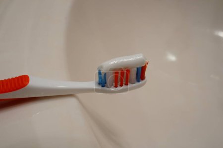 Foto de Pasta de dientes en un cepillo de dientes en un fregadero. - Imagen libre de derechos