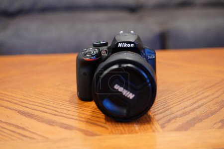 Photo for Fond du Lac, Wisconsin USA - May 19th, 2024: Old Nikon D3400 ASP-C sensor digital camera sits on a coffee table. - Royalty Free Image