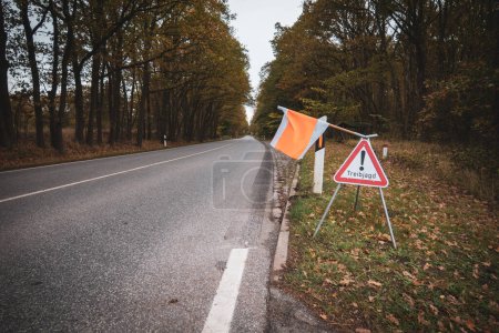 Photo for On the side of the road there is a sign with a flag with the warning Attention Drift Hunting - Royalty Free Image