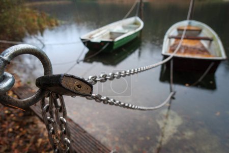 Photo for Rowing boats an a lake are secured with a chain and a padlock - Royalty Free Image
