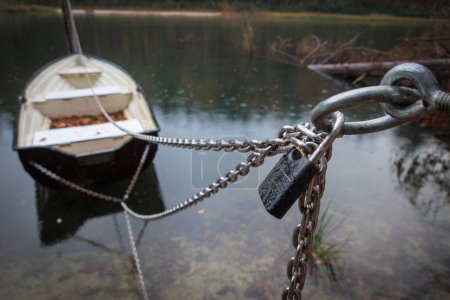 Photo for Rowing boats an a lake are secured with a chain and a padlock - Royalty Free Image