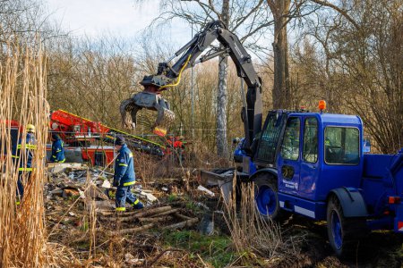 Photo for Members of THW remove construction debris with the help of a wheeled excavator  in Schoenberg, Germany - Royalty Free Image