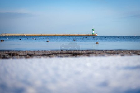 The green lighthouse at the entrance to Luebeck harbor in winter
